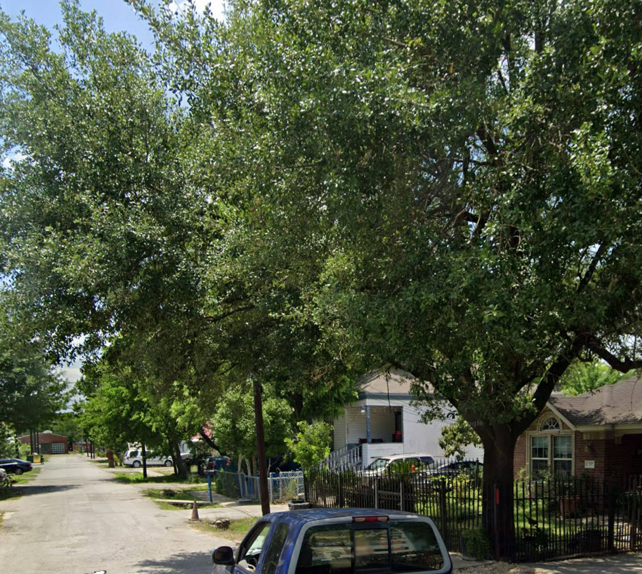 A street with trees and houses

Description automatically generated