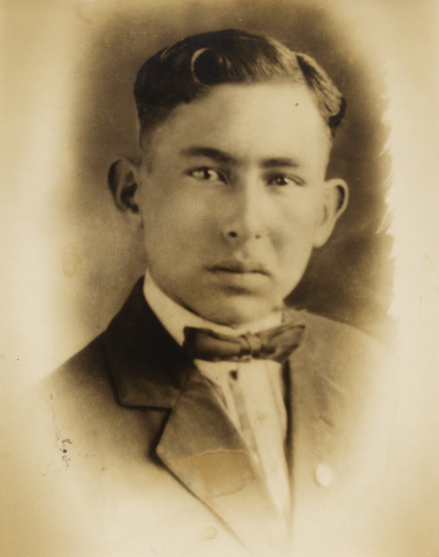 A person in a suit and bow tie

Description automatically generated