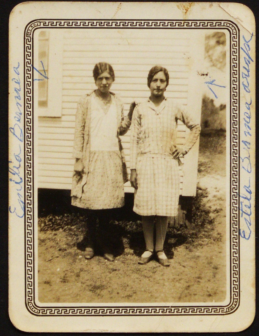 A couple of women standing in front of a house

Description automatically generated